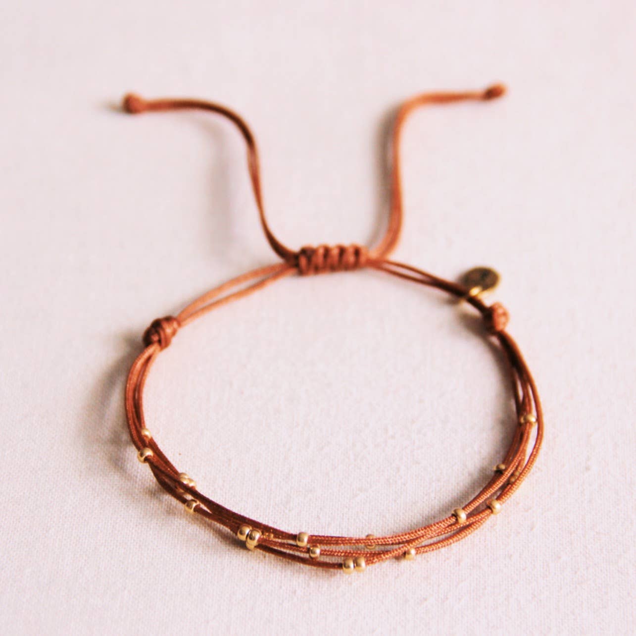 Viervoudige satijnen armband met kralen - cognac