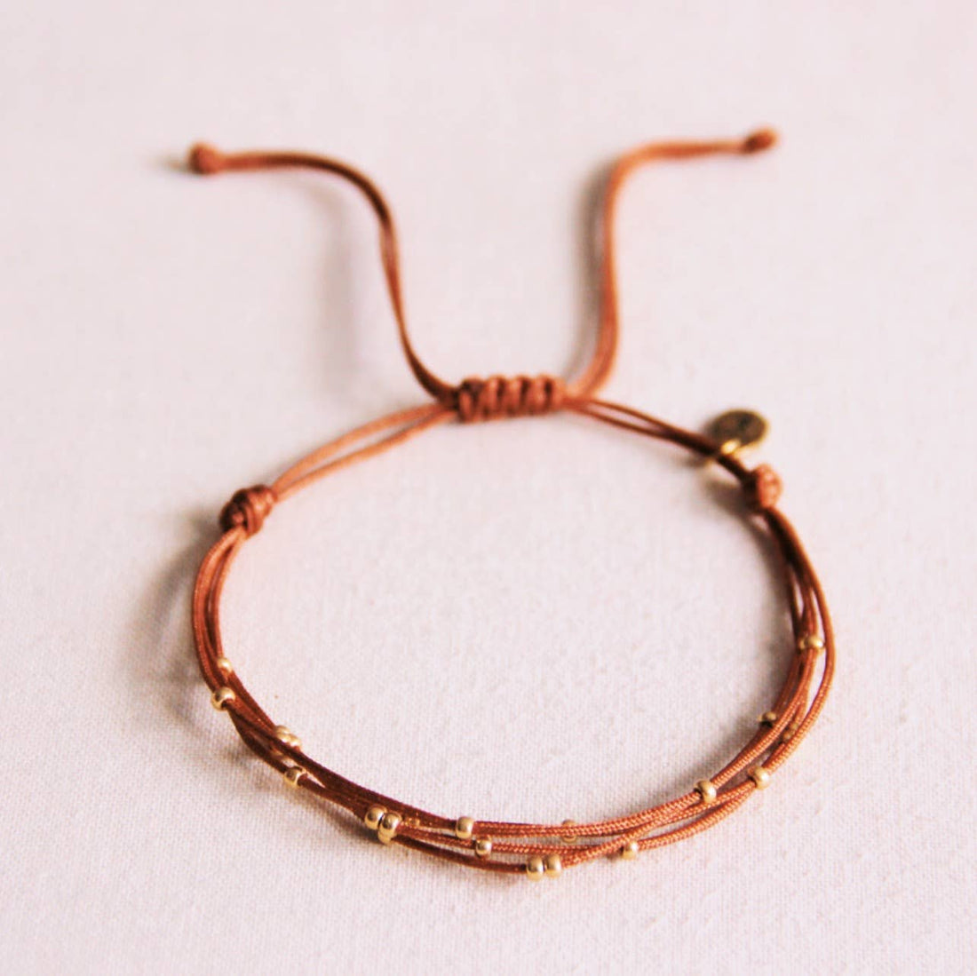 Viervoudige satijnen armband met kralen - cognac