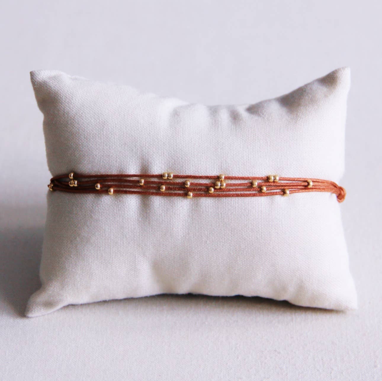 Viervoudige satijnen armband met kralen - cognac